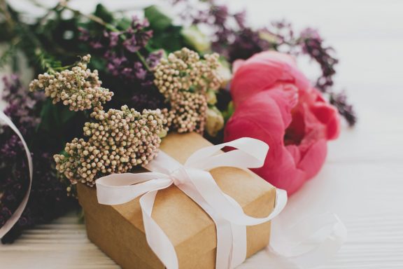 Luxuriöse Geschenkboxen mit weißen Schleifen und pinken Rosen - Blumenladen Isny