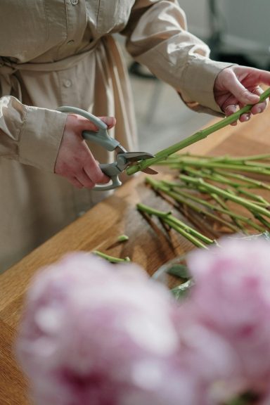 Hände binden geschickt frische grüne Stiele zusammen - Floristik Handwerk Workshop Isny