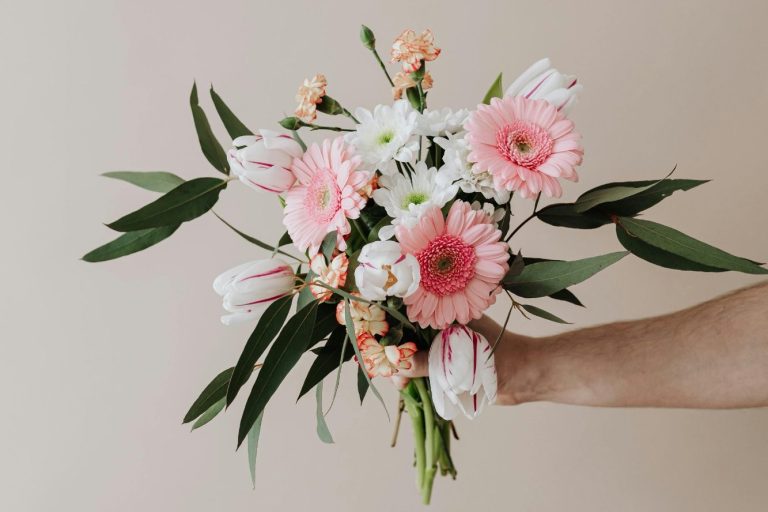 Eleganter Brautstrauß mit rosa Gerbera und weißen Blüten auf beigem Hintergrund - Kreativ & Blüte Isny